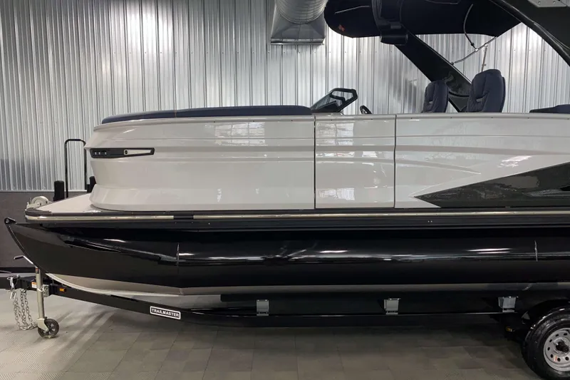 Slide: The Image of 2025 Sylvan M3 DLZ DH Tritoon boat on trailer in showroom setting. - 16