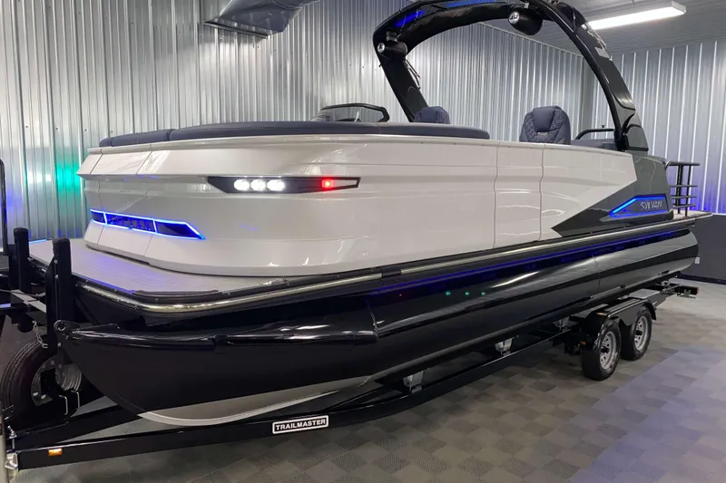 Slide: The Image of 2025 Sylvan M3 DLZ DH Tritoon boat in showroom, sleek design with modern lighting. - 21