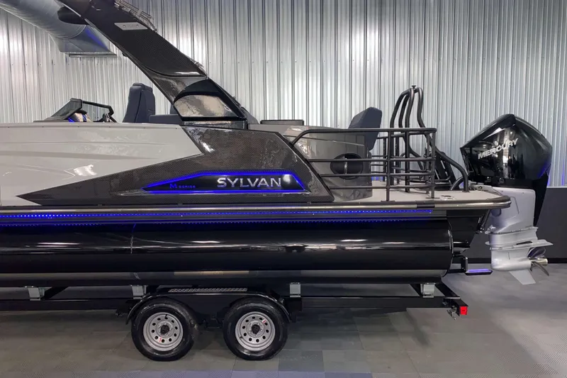 Slide: The Image of 2025 Sylvan M3 DLZ DH Tritoon boat with Mercury outboard motor on trailer. - 25
