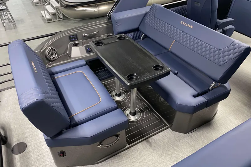 Slide: The Image of Luxurious seating area on 2025 Sylvan M3 DLZ DH Tritoon with blue upholstery and table. - 3