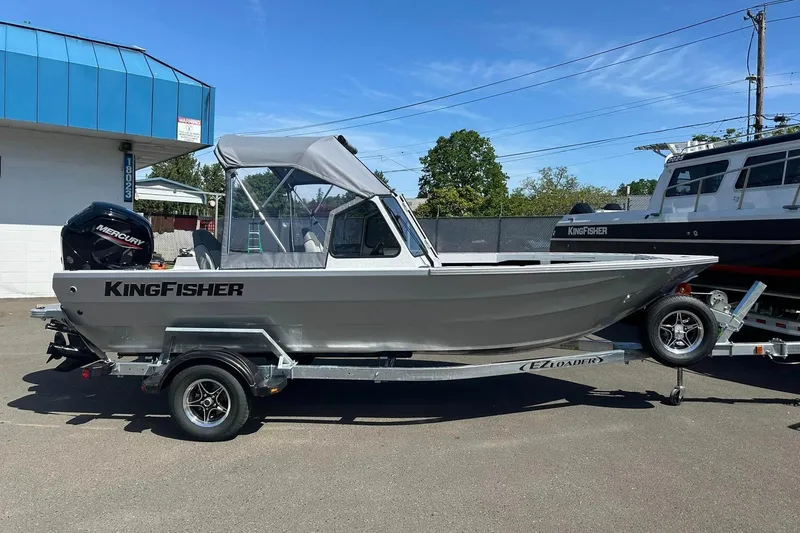The Image of 2026 KingFisher 1825 Warrior Sport boat on trailer, parked outdoors under clear sky. - 1