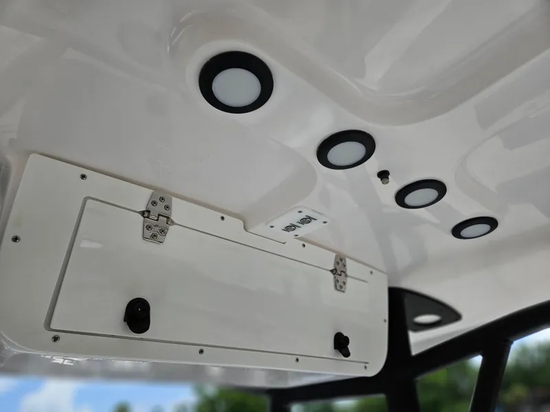 Slide: The Image of 2025 Sea Hunt Ultra 219 boat interior ceiling with storage compartment and recessed lighting. - 13