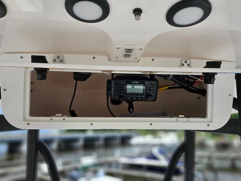 Slide: The Image of 2025 Sea Hunt Ultra 219 boat console with electronic equipment and storage compartment. - 14