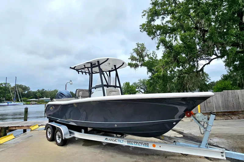 Slide: The Image of 2026 Sea Hunt Ultra 219 boat on trailer by waterfront, overcast sky. - 4