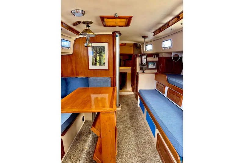 Slide: The Image of Interior of a 1971 Pearson Competitor sailboat with wood finishes and blue seating. - 10