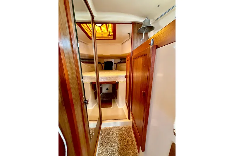 Slide: The Image of Interior of a 1971 Pearson Competitor sailboat with wooden cabinetry and cozy sleeping area. - 11