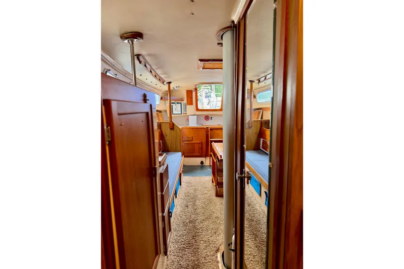 Slide: The Image of Interior of a 1971 Pearson Competitor sailboat with wooden cabinetry and cozy seating. - 12