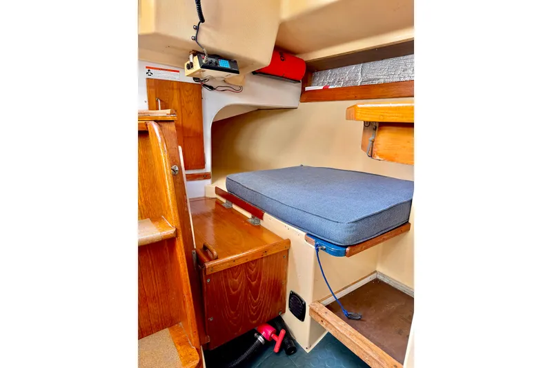 Slide: The Image of 1971 Pearson Competitor sailboat interior with wooden cabinetry and blue cushion. - 15