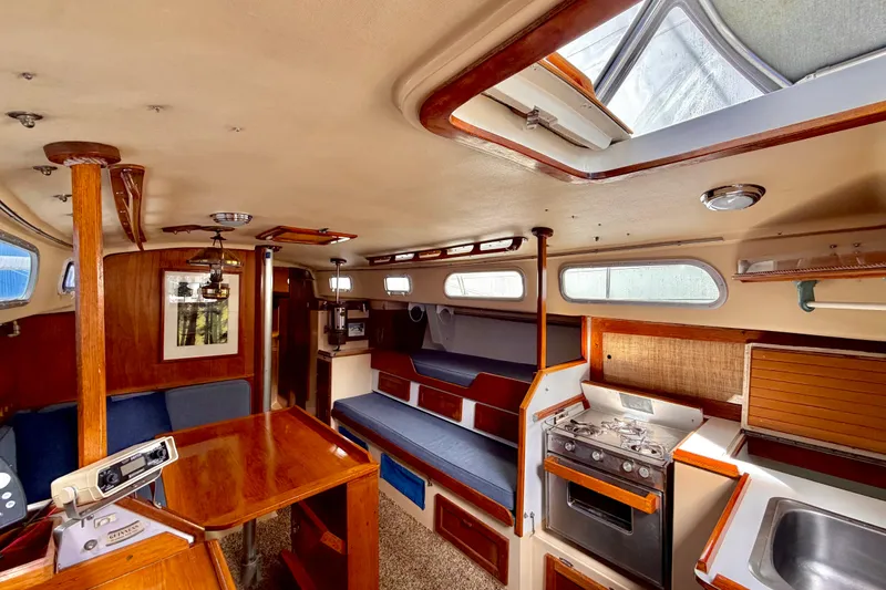 Slide: The Image of Interior of a 1971 Pearson Competitor sailboat with wood accents and compact kitchen. - 6