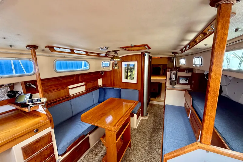 Slide: The Image of Interior of a 1971 Pearson Competitor sailboat with wooden furnishings and blue seating. - 7
