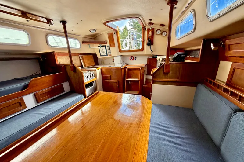 Slide: The Image of Interior of a 1971 Pearson Competitor sailboat with wooden furnishings and cozy seating. - 8