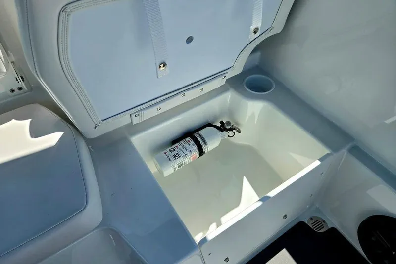 Slide: The Image of Storage compartment in a 2026 Tahoe T18 boat with a fire extinguisher. - 23