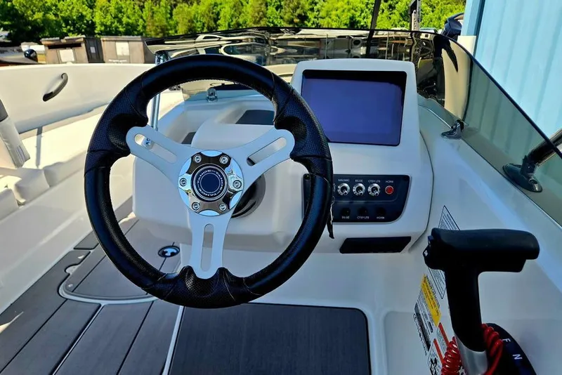 Slide: The Image of Steering wheel and dashboard of 2026 Tahoe T18 boat, featuring modern controls and display. - 40