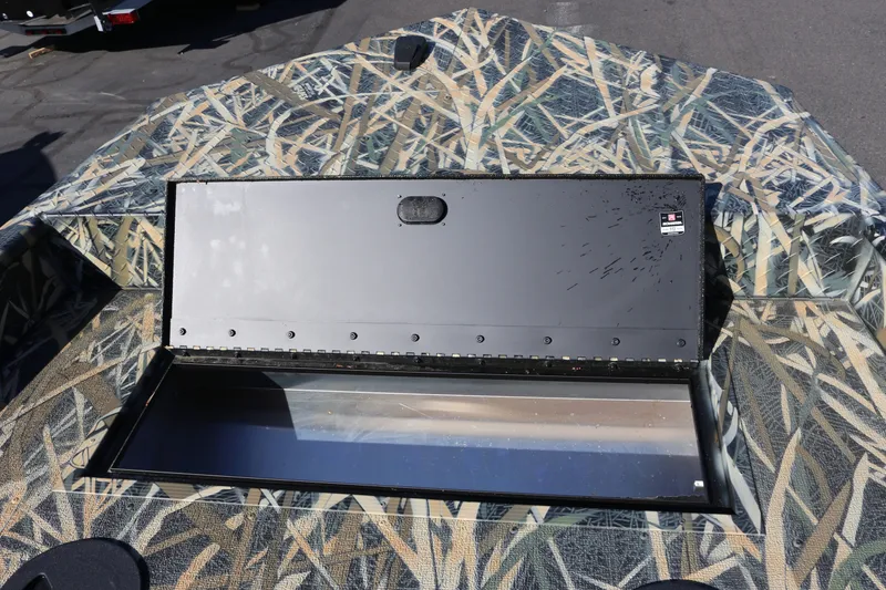 Slide: The Image of 2026 Smoker Craft Sportsman 1660 boat with open storage compartment, camo design. - 6