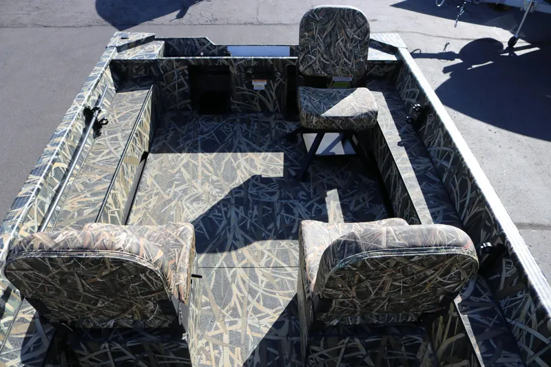 Slide: The Image of 2026 Smoker Craft Sportsman 1660 boat interior with camouflage seating and flooring. - 7