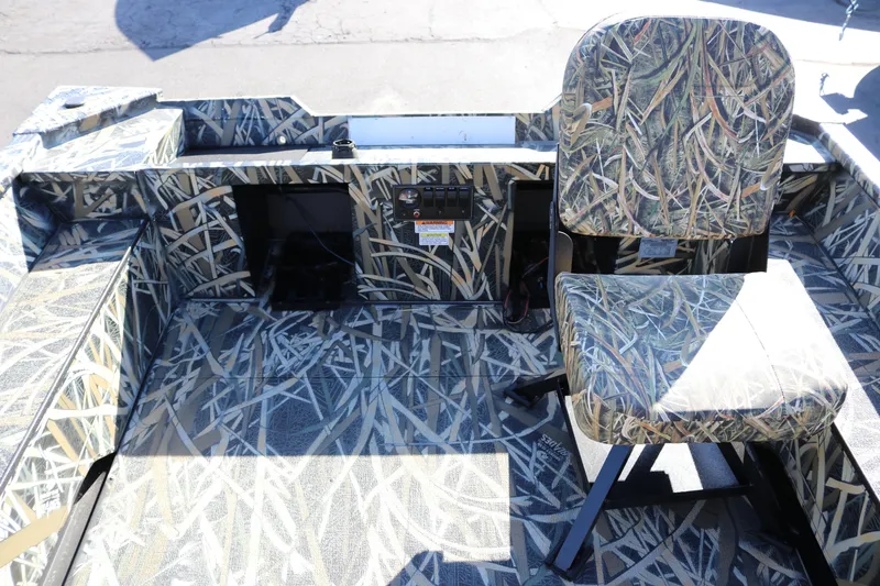 Slide: The Image of 2026 Smoker Craft Sportsman 1660 boat interior with camouflage seating and flooring design. - 8