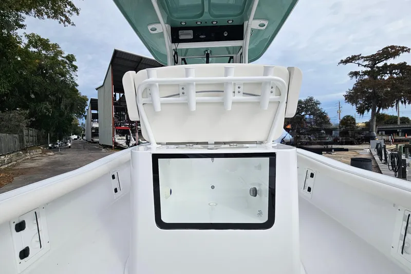 Slide: The Image of 2026 Sea Hunt BX 25 FS boat interior with seating and storage, dockside view. - 11