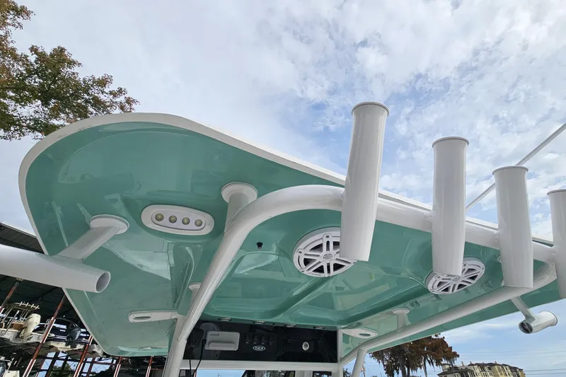 Slide: The Image of 2026 Sea Hunt BX 25 FS boat top with rod holders and speakers under a cloudy sky. - 16