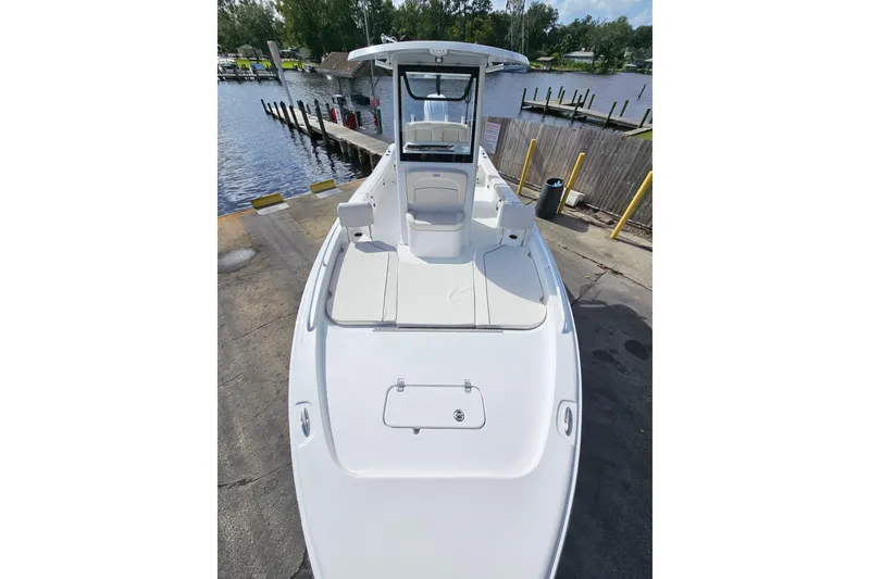 Slide: The Image of 2026 Sea Hunt BX 25 FS boat docked, showcasing spacious deck and seating area. - 25