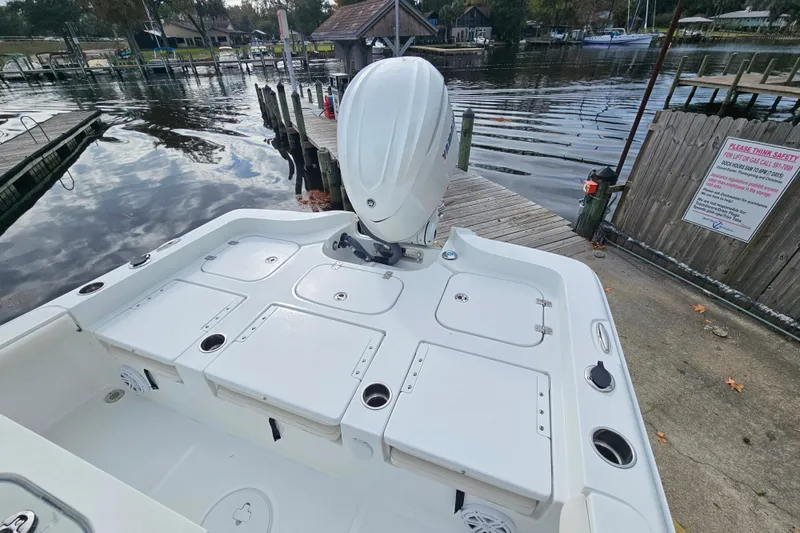 Slide: The Image of 2026 Sea Hunt BX 25 FS boat docked by a serene waterfront. - 7