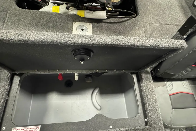 Slide: The Image of 2026 Tracker Targa V-19 Combo boat storage compartment with open lid and visible interior. - 11