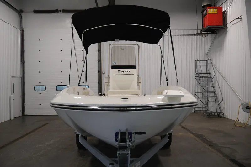 Slide: The Image of 2026 Bayliner Trophy T18 boat in a garage, featuring a sleek design and black canopy. - 11