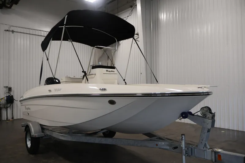Slide: The Image of 2026 Bayliner Trophy T18 boat with canopy on trailer in indoor storage. - 12