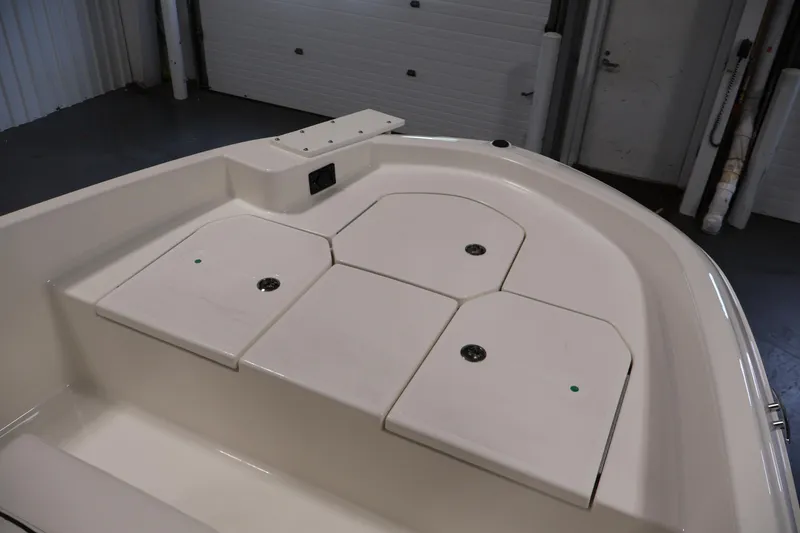 Slide: The Image of 2026 Bayliner Trophy T18 boat interior with storage compartments in a showroom setting. - 17