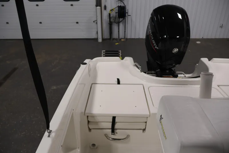 Slide: The Image of 2026 Bayliner Trophy T18 boat interior with Mercury engine in a garage setting. - 38