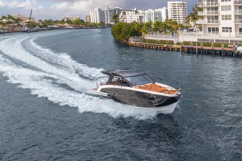 Slide: The Image of 2026 Hanover 387 yacht cruising in a scenic urban waterway with modern buildings. - 11