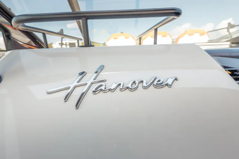 Slide: The Image of Close-up of 2026 Hanover 387 logo on a sleek white surface. - 14