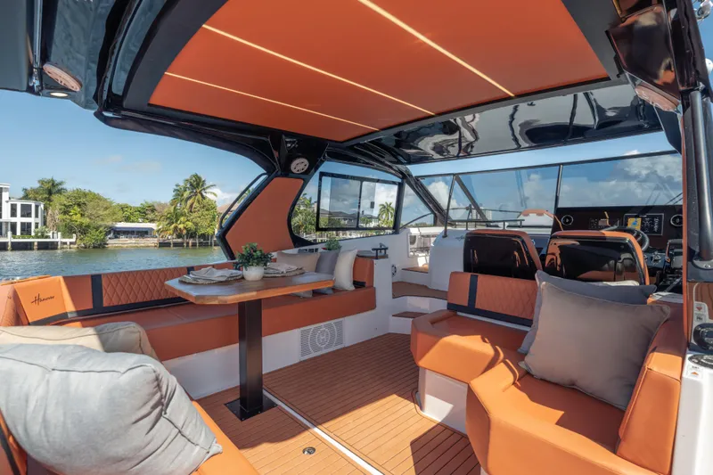 Slide: The Image of Luxurious 2026 Hanover 387 yacht interior with orange seating, elegant table, and scenic waterfront view. - 31