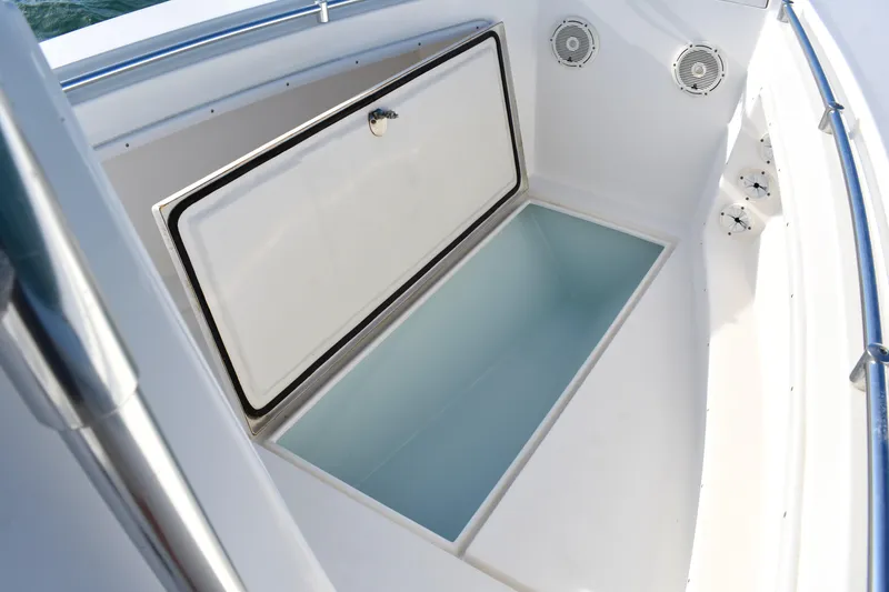 Slide: The Image of 2014 Contender 23 Open boat storage compartment with open hatch and speakers. - 10