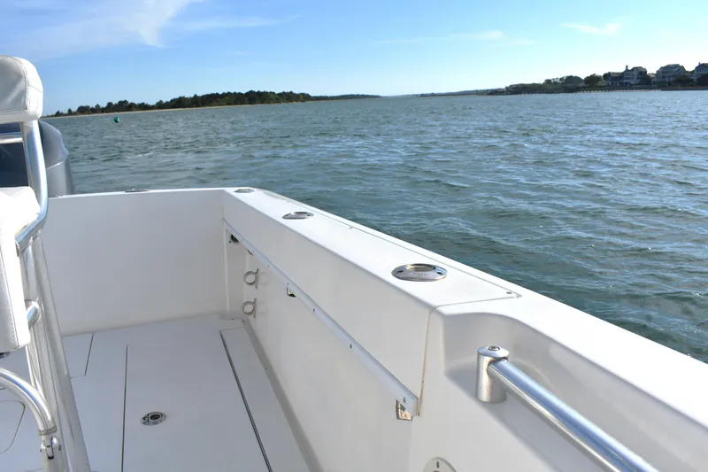 Slide: The Image of 2014 Contender 23 Open boat on calm water, showcasing spacious deck and scenic view. - 17