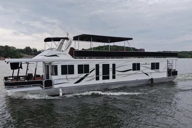 The Image of 2004 Starlite 65x16 houseboat cruising on a calm lake. - 0