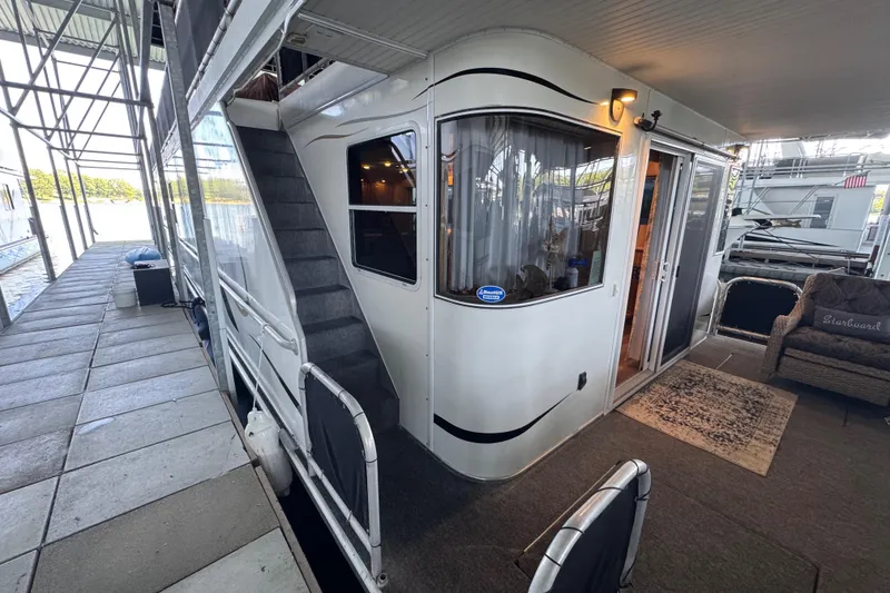 Slide: The Image of Houseboat docked with outdoor seating, featuring Starlite 65x16 model from 2004. - 18