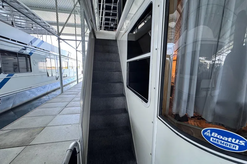 Slide: The Image of Starlite 65x16 houseboat, 2004 model, docked with visible stairs and BoatUS member sticker. - 19
