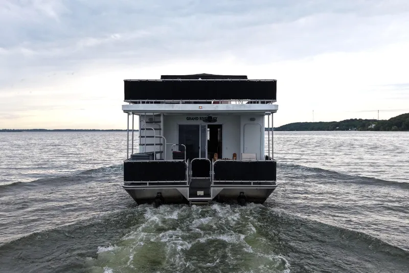 Slide: The Image of Starlite 65x16 houseboat from 2004 on a calm lake. - 3