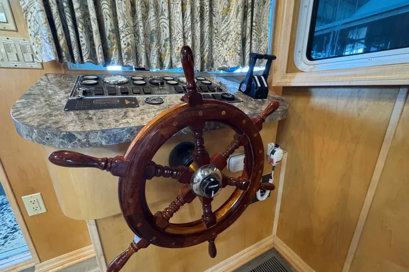 Slide: The Image of Wooden ship wheel and control panel in a 2004 Starlite 65x16 boat interior. - 32