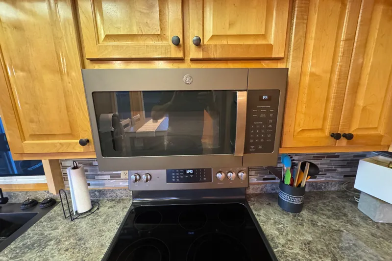 Slide: The Image of Modern kitchen with stainless steel microwave, wooden cabinets, and granite countertop. Starlite 65x16, 2004. - 38