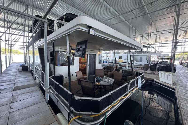 Slide: The Image of Houseboat docked in marina, Starlite 65x16 model, 2004, with outdoor seating area. - 6
