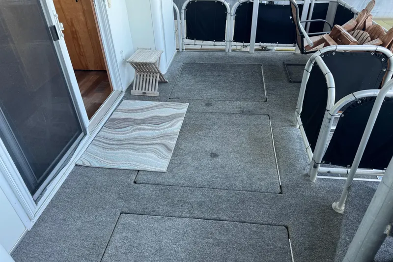 Slide: The Image of Carpeted deck area on a 2004 Starlite 65x16 houseboat with chairs and a small table. - 74