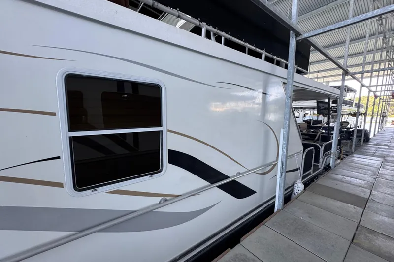 Slide: The Image of 2004 Starlite 65x16 houseboat docked under a covered marina. - 8