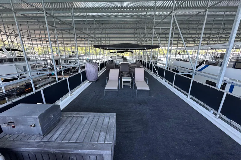 Slide: The Image of Covered deck area on a 2004 Starlite 65x16 houseboat with lounge chairs and tables. - 82