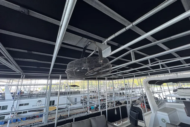 Slide: The Image of Rooftop view of a 2004 Starlite 65x16 houseboat with metal framework and ceiling fan. - 90