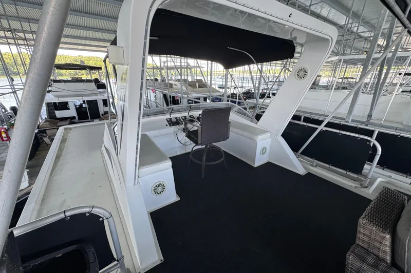 Slide: The Image of 2004 Starlite 65x16 houseboat helm with seating under covered dock. - 91