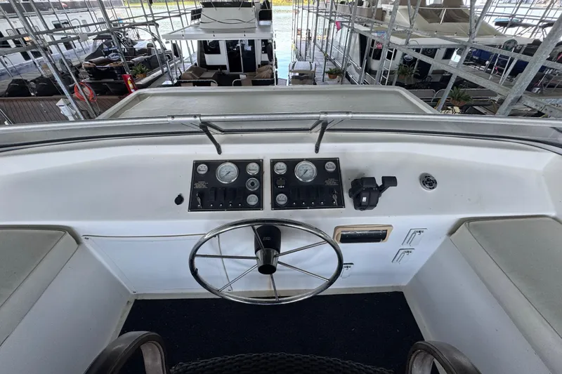 Slide: The Image of Control panel of a 2004 Starlite 65x16 boat with steering wheel and gauges. - 92