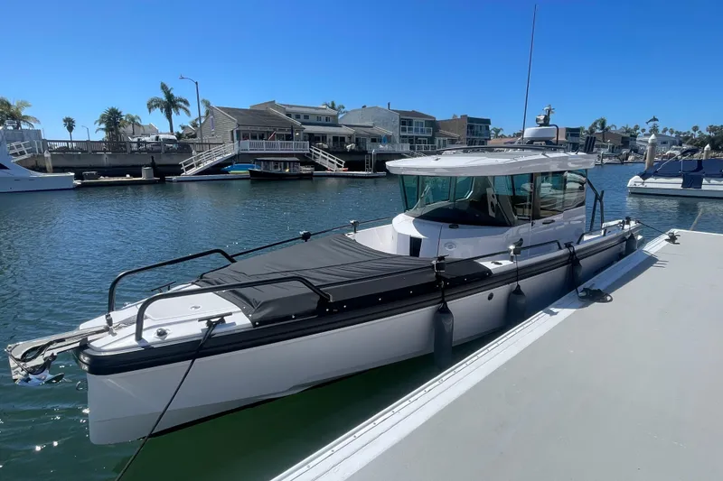 The Image of 2022 Axopar Brabus 28 Cabin boat docked in a sunny marina setting. - 1