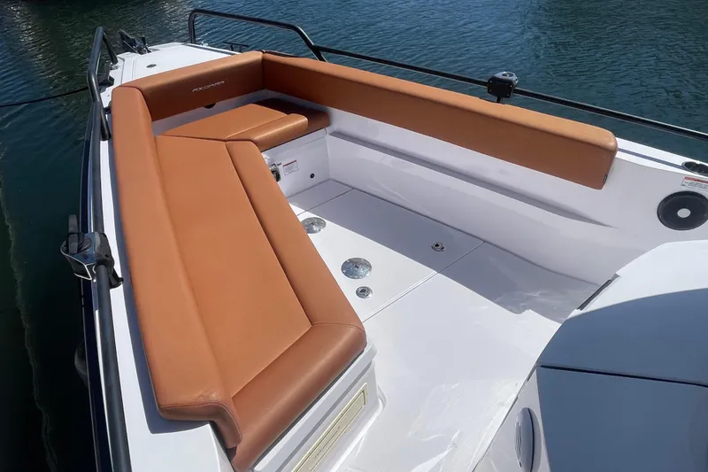 Slide: The Image of 2022 Axopar Brabus 28 Cabin boat with tan seating, docked on water. - 11