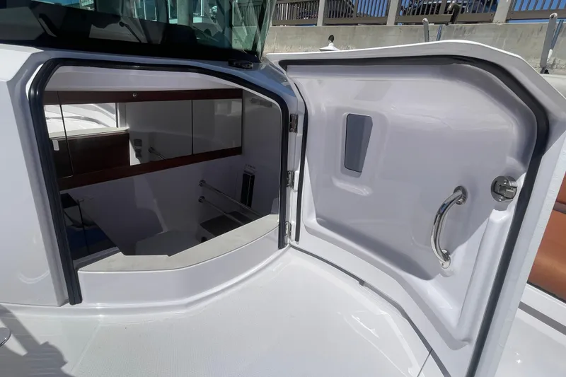 Slide: The Image of 2022 Axopar Brabus 28 Cabin interior entrance with open door and visible stairs. - 13